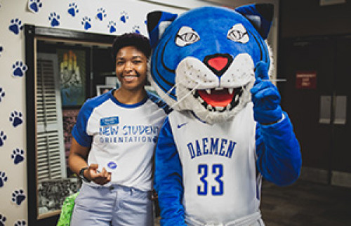 Willie the Wildcat and student in a New Student Orientation t-shirt 