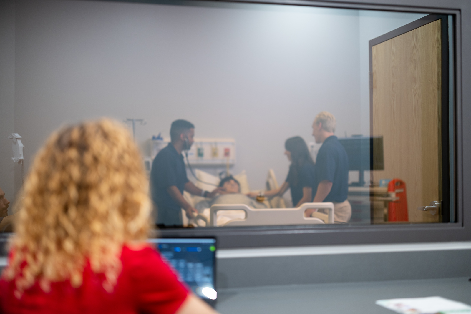Supervisor observing students in simulation room