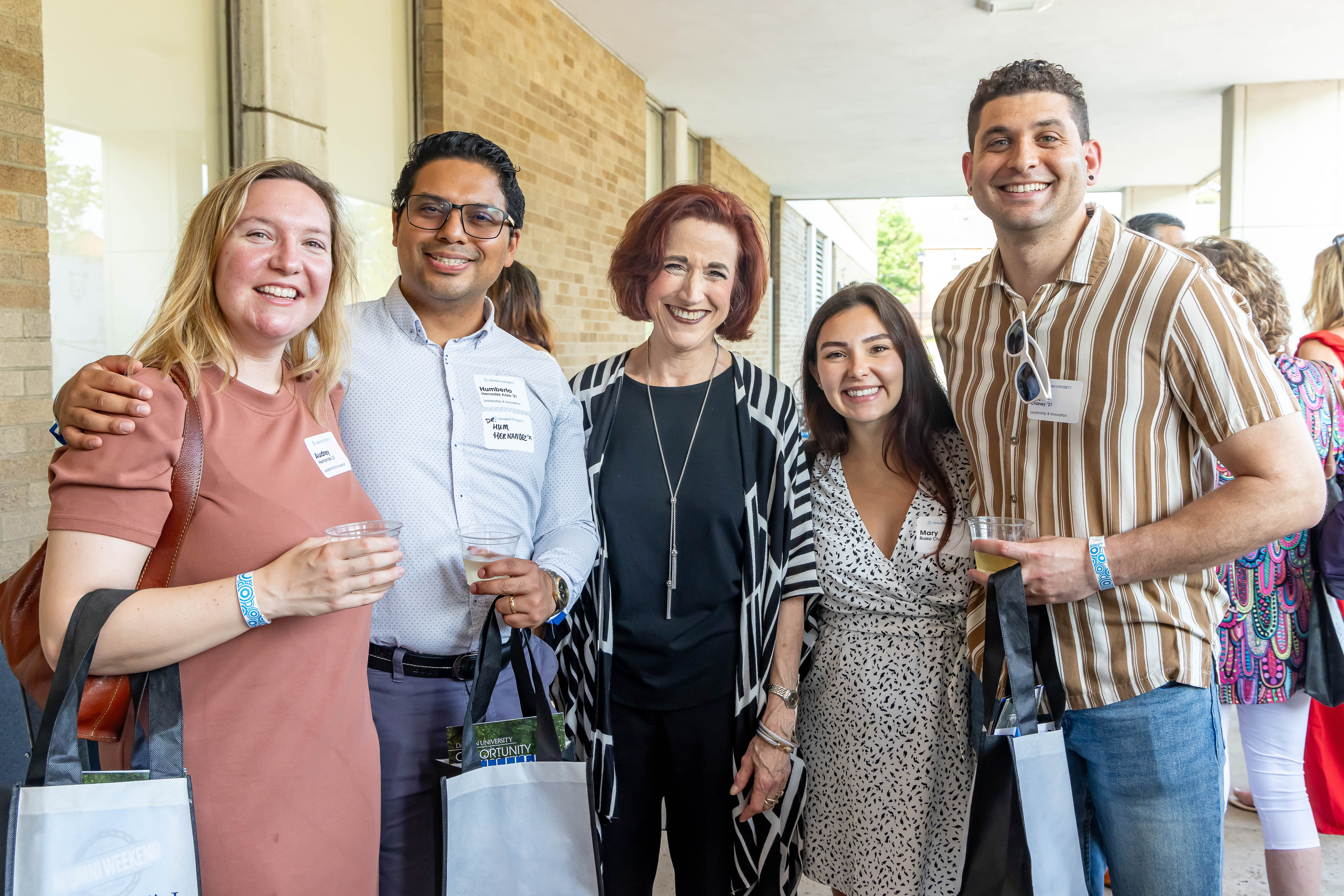 five people, standing outside campus building