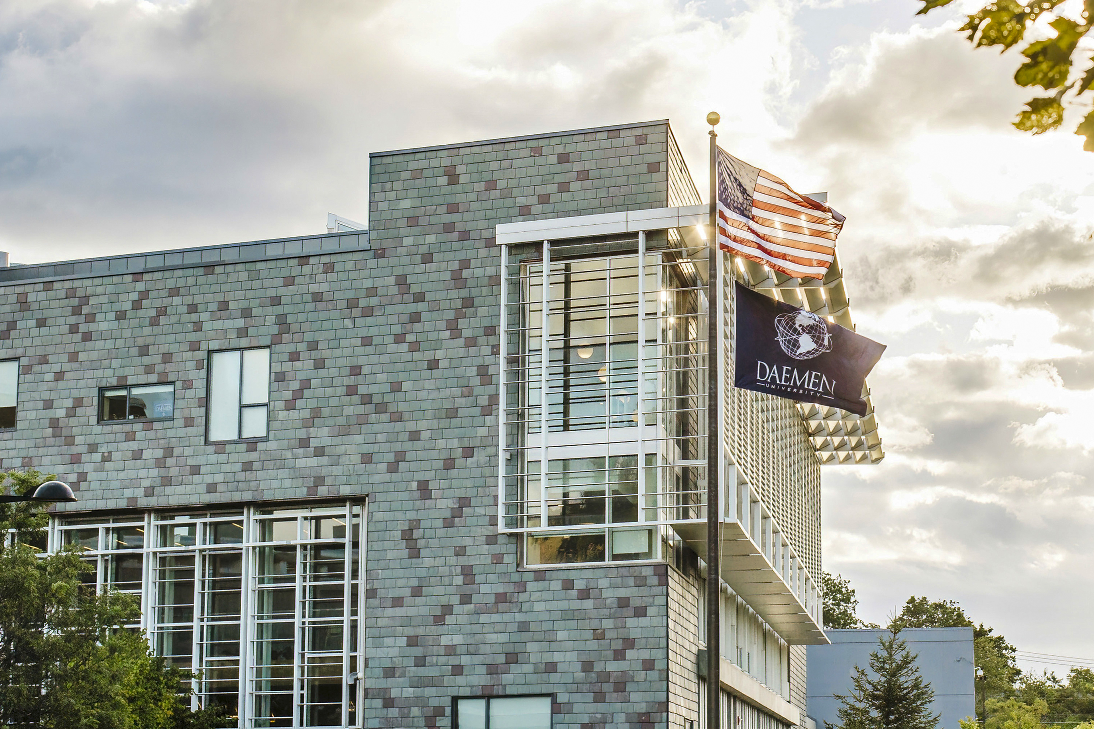 Modern building with the American and Daemen flags flying on a flag pole