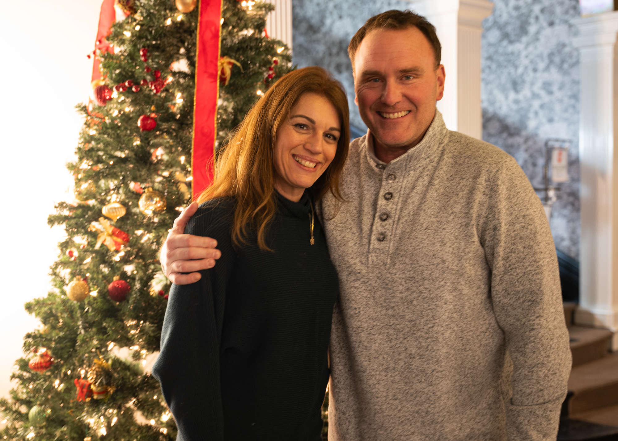 two people stand in front of decorative tree