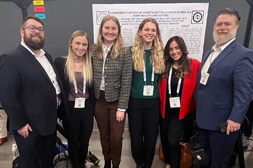 Professors at CSM standing in front of poster