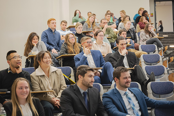 Symposium attendees sitting down smiling