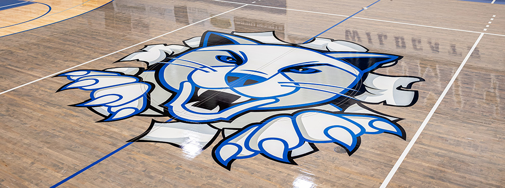 Floor of Lumsden Gym with wildcat logo on it