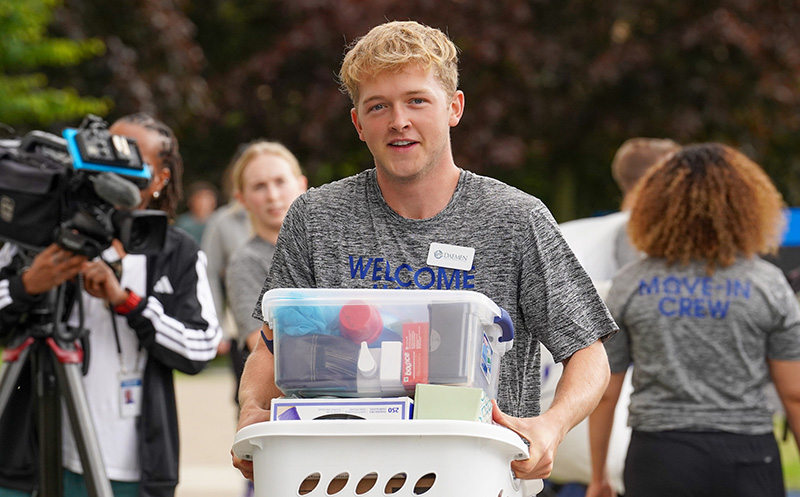 Student holding laundry basket at move in weekend