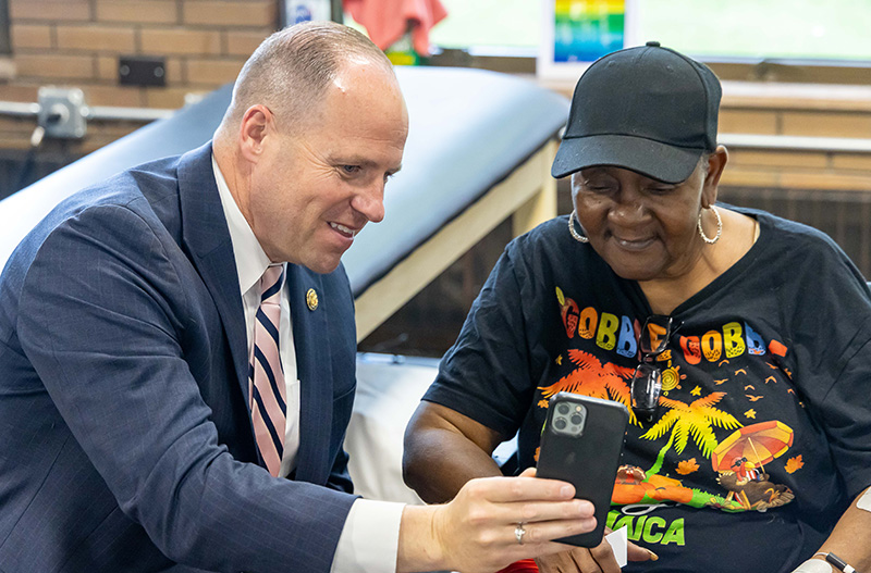 Tim Kennedy showing a patient something on his phone at the Kennedy Institute