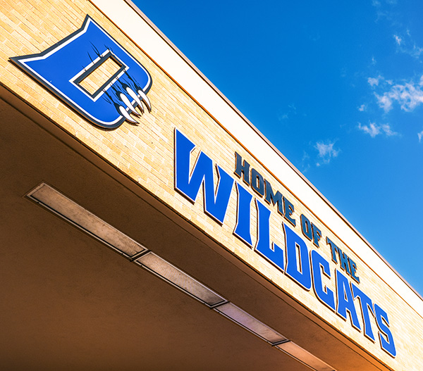 Home of the Wildcats sign on outside of building