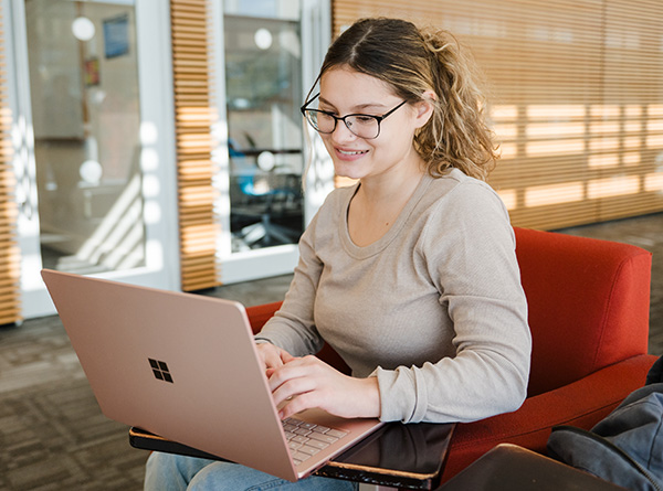 Student sitting in chair with laptop on third floor of RIC
