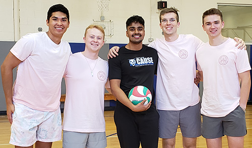 Breast cancer awareness fundraiser participants in lumsden gym wearing pink T-shirts.
