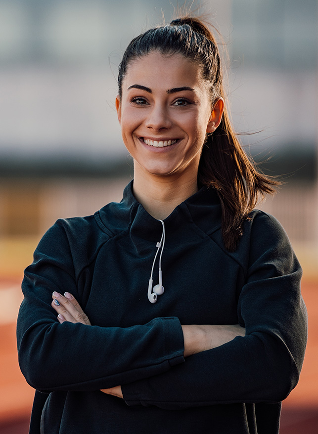 Female coach smiling on outdoor track