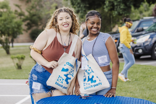 Two female students smiling holding Daemen Block Party bags