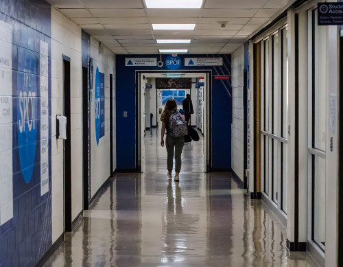 student walking away from the camera down the hallway of wick