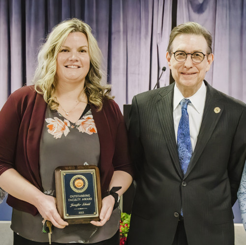 Dr. Jennifer Scheid holding her award with Dr. Olson