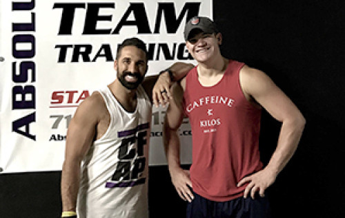 Two guys in tank tops in a gym