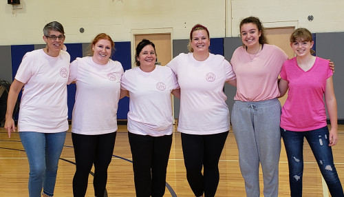 Breast cancer awareness fundraiser participants in lumsden gym wearing pink T-shirts.