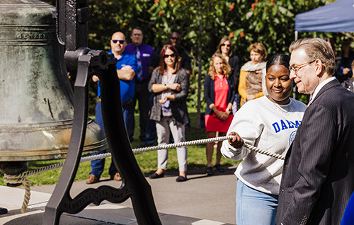 Student Ringing Founders Bell with President Olson