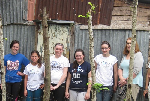Daemen students standing arm in arm outside in a town they are volunteering in