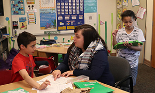 Female Daemen student working with elementary students