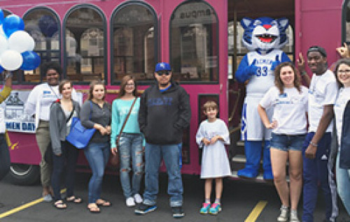 Daemen community posing by trolly getting ready to go to Amherst