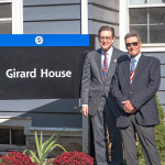 President Olson standing by Girard House sign