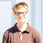 Zorian wearing a brown short sleeved polo shirt