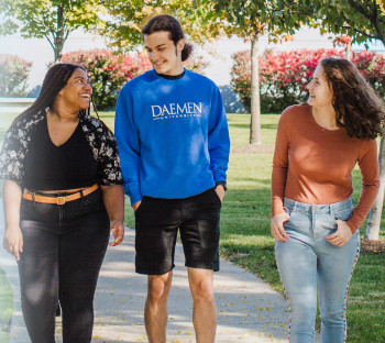 Three students walking and talking on campus